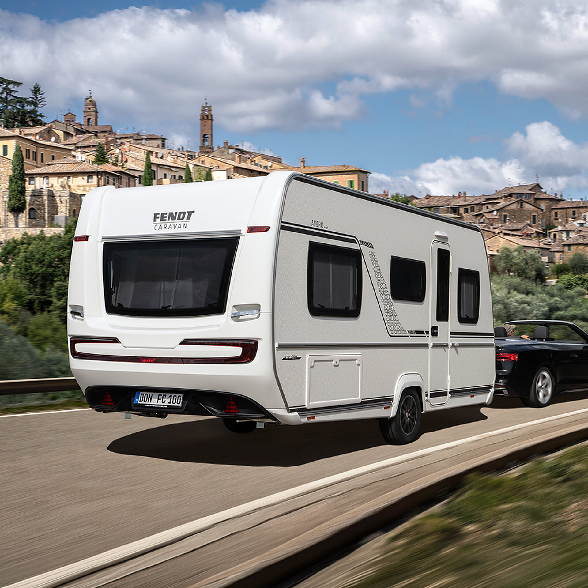 Ein Fendt-Caravan APERO fährt eine Straße entlang.