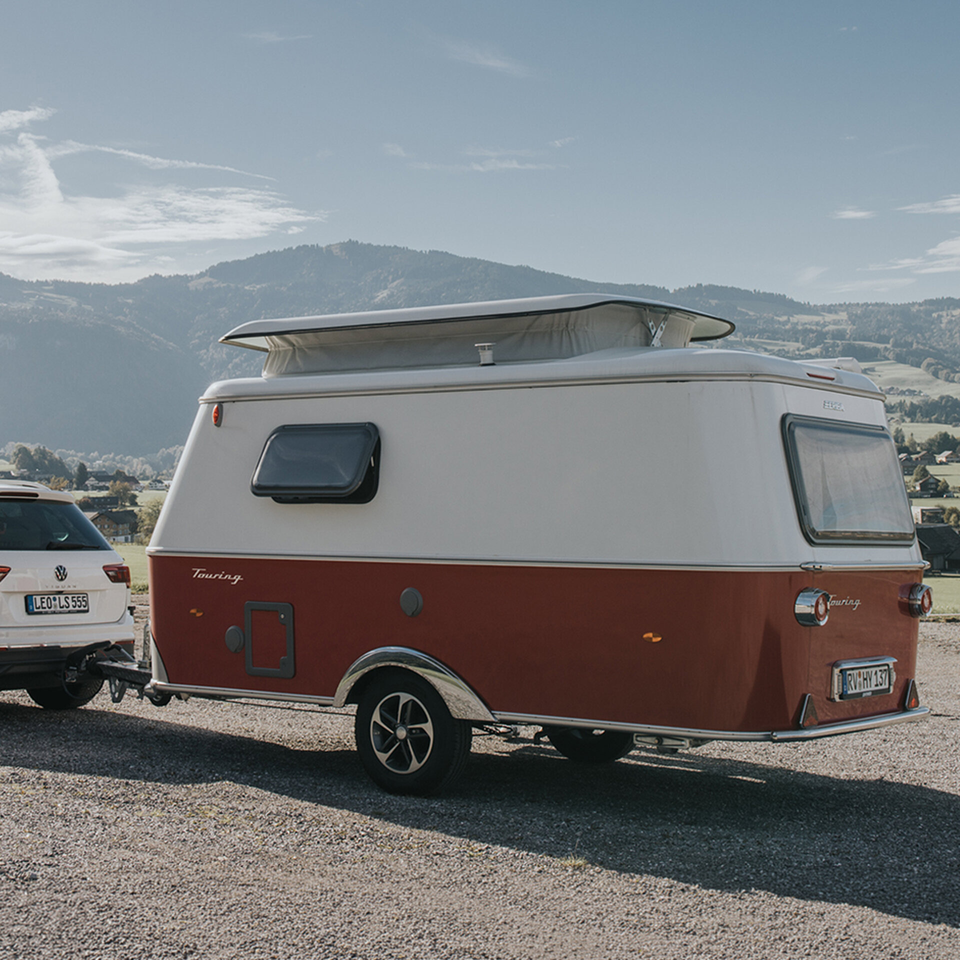 Ein ERIBA Touring parkt auf einem Parkplatz in einer Berglandschaft.