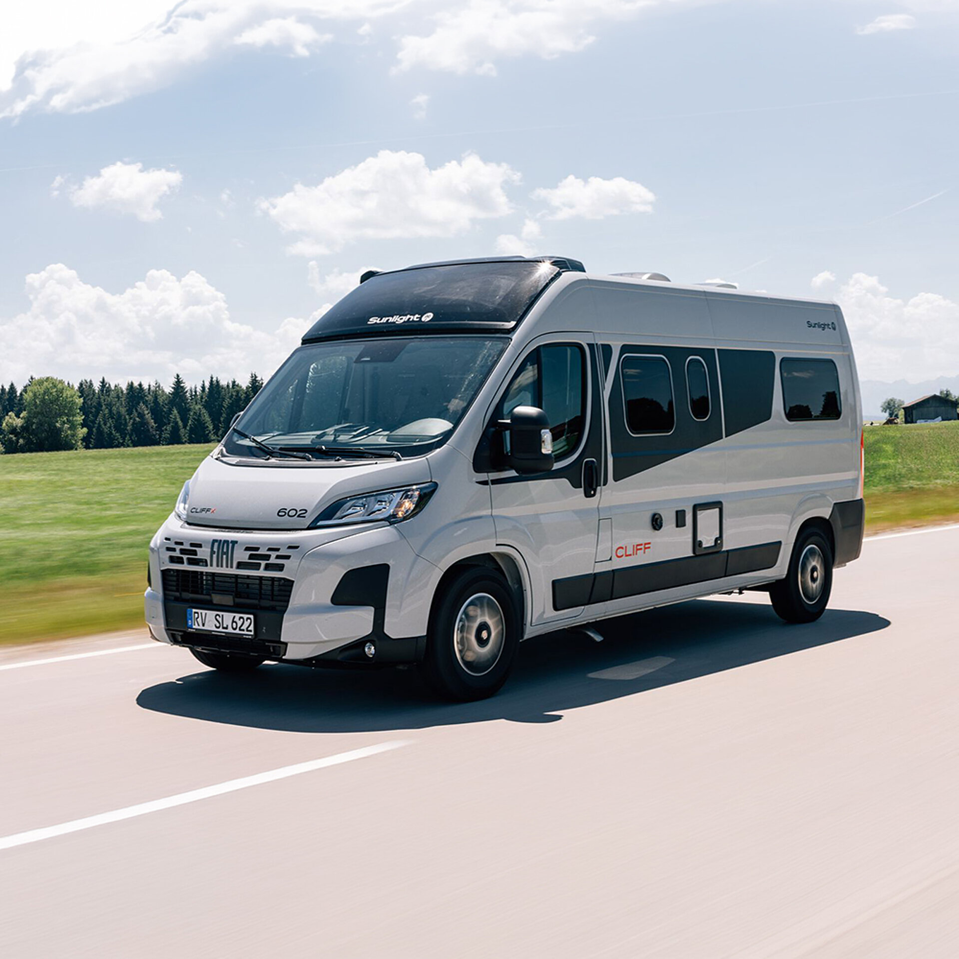 Ein CLIFF X Kastenwagen fährt eine Landstraße entlang.