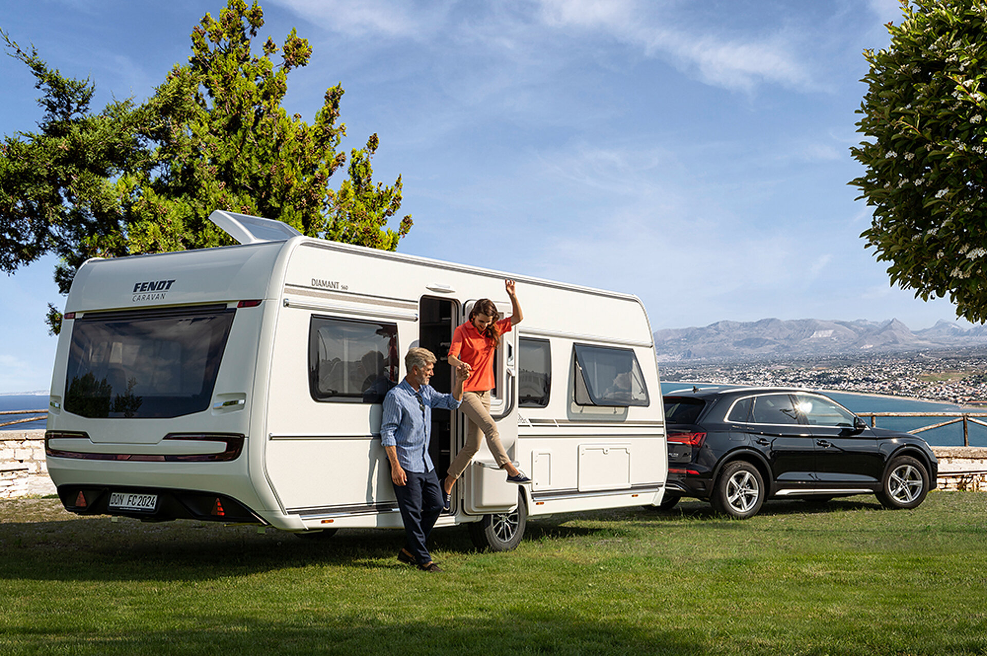 Ein Mann hilft seiner Frau dabei, aus einem Wohnwagen von Fendt-Caravan auszusteigen.